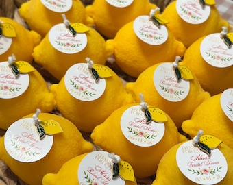 Puede incluir: Una colección de objetos de color amarillo brillante con forma de limón dispuestos en una cesta tejida. Cada limón tiene una pequeña etiqueta circular blanca unida con un cordel, con el texto 'THANKS FOR COMING', 'Alaa's Bridal Shower' y '06-14-26'.