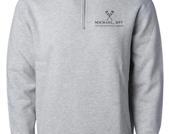 May include: A light gray sweatshirt with a quarter-zip neckline. The sweatshirt features the text "MICHAEL, DPT DOCTOR OF PHYSICAL THERAPY" in black, along with a graphic of crossed crutches. The long-sleeved top has ribbed cuffs and a ribbed hem.