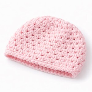 May include: A light pink crocheted beanie hat. The hat is made of a soft, textured yarn and features a simple, open stitch pattern. The brim is folded up, and the hat is designed to fit snugly on the head.