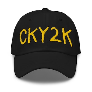 May include: Black baseball cap with the embroidered text "CKY2K" in yellow. The hat has a curved brim and an adjustable strap at the back. A classic, casual accessory.