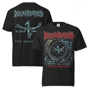 May include: Black t-shirts featuring the band "Decapitated." One shirt displays the band's name in red, with a circular design and the text "THE NEGATION." The other shirt shows the band's name in blue, with a symbol and the text "THE NEGA."