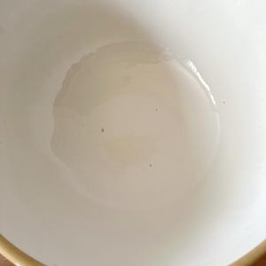 K&ouml;nnte beinhalten: Eine wei&szlig;e Keramik-R&uuml;hrsch&uuml;ssel mit beigem Rand. Die Sch&uuml;ssel hat eine glatte, gl&auml;nzende Oberfl&auml;che und eine abgerundete Form. Im Inneren der Sch&uuml;ssel scheint sich eine fl&uuml;ssige Substanz zu befinden.