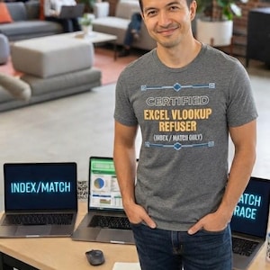 May include: A heather gray short-sleeve t-shirt featuring the text CERTIFIED EXCEL VLOOKUP REFUSER (INDEX/MATCH ONLY) in white and yellow lettering with blue geometric accents. The shirt is made of a soft fabric and has a crew neckline.