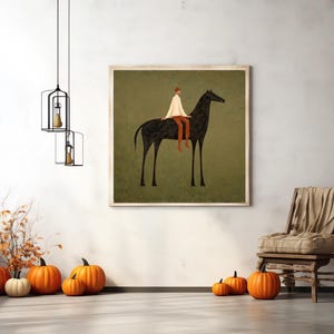 May include: A framed art print depicts a person riding a black horse against a muted green background. The rider wears a white top and orange pants. The room features pumpkins, a wooden chair, and hanging light fixtures.