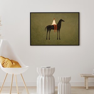 May include: A framed art print depicts a person riding a black horse against a muted green background. The rider wears a white garment and brown pants. The artwork is displayed on a white wall, complemented by a modern chair and decorative elements.