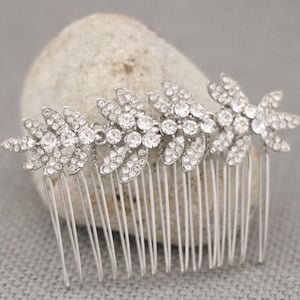 May include: Silver hair comb with a row of crystal rhinestones in a leaf design.