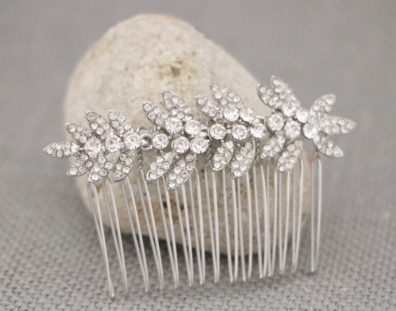 May include: Silver hair comb with a row of crystal rhinestones in a leaf design.