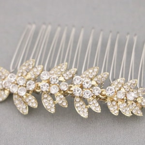 May include: Gold hair comb with a row of clear rhinestones in a leaf design.