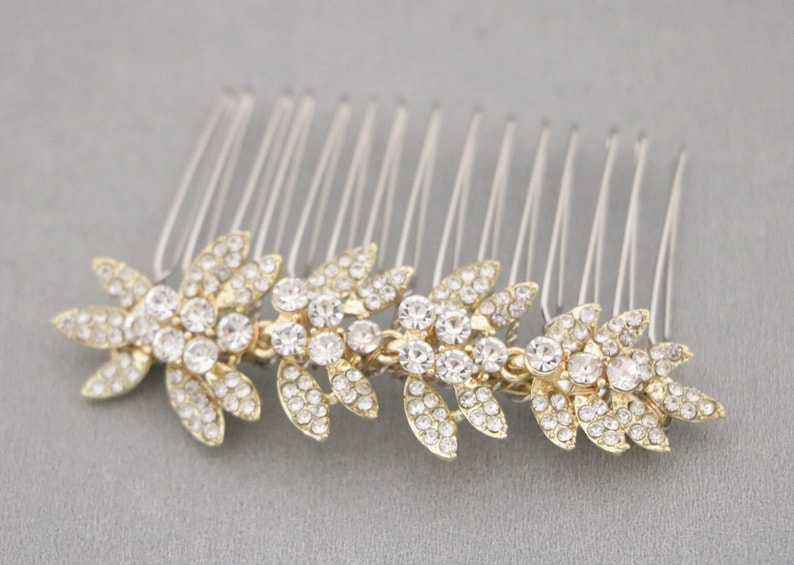 May include: Gold hair comb with a row of clear rhinestones in a leaf design.