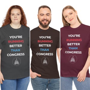 Pu&ograve; includere: Tre magliette con la scritta "YOU'RE RUNNING BETTER THAN CONGRESS" in bianco, rosso e blu. Le magliette sono grigio scuro, marrone e bordeaux. Ogni maglietta ha una grafica di un edificio.