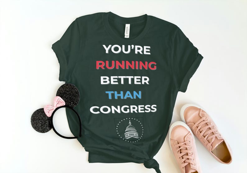 Pu&ograve; includere: T-shirt verde scuro con la scritta "YOU'RE RUNNING BETTER THAN CONGRESS" in bianco, rosso e blu. Include un paio di scarpe da ginnastica rosa e orecchie di topo nere con un fiocco rosa.