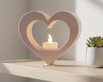 May include: A wooden shelf displays a heart-shaped candle holder with a lit candle, a small potted succulent, and a framed abstract art print. The items are in neutral tones, creating a calming aesthetic. A window with a city view is in the background.