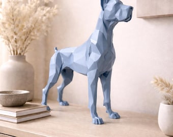 May include: A light blue geometric dog sculpture. The dog is standing on all fours with its head up and ears perked. The sculpture is made of many flat, angular surfaces. The dog is on a wooden surface.