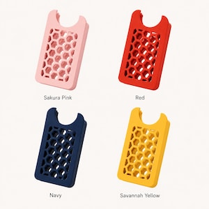 May include: Four colorful phone card holders in Sakura Pink, Red, Navy, and Savannah Yellow. Each holder has a honeycomb pattern and a curved top. The names of the colors are printed below each holder.