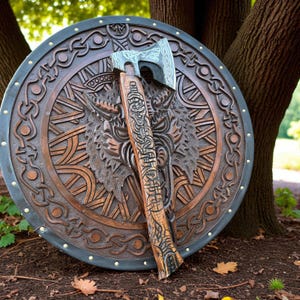 May include: A wooden shield and axe set. The shield is round with a dark brown finish and intricate carvings of a wolf's head and Celtic knot patterns. The axe has a silver blade and a wooden handle with detailed carvings.