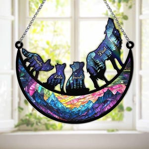 Pode incluir: Decoração de parede com uma família de lobos em silhueta contra um céu estrelado. O design inclui os nomes "Murphy", "Lola", "Jacob" e "Dad". A parte inferior retrata montanhas coloridas.