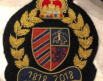 May include: A black embroidered patch with a gold crown, laurel leaves, and a shield design. The shield features red and blue stripes and a crest. The text "EVOCHICS MC" is above the shield, and "1878-2018" is below.