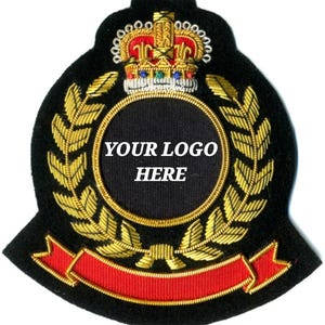 May include: A black embroidered patch with gold laurel leaves, a red banner, and a gold and red crown. The center features a black circle with the text "YOUR LOGO HERE" in white.