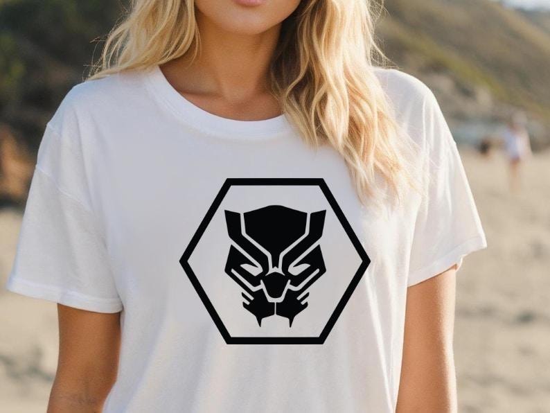 May include: White t-shirt featuring a black graphic of a panther's face within a black hexagon. The design is centered on the shirt. The shirt is made of a soft material.