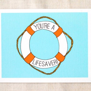 Puede incluir: Un salvavidas blanco y naranja con un asa de cuerda sobre un fondo azul. El salvavidas tiene el texto "YOU'RE A LIFESAVER!" escrito en él.