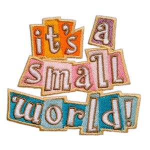 Pode incluir: Patch bordado com a frase "it's a small world!" em letras brancas sobre formas retangulares coloridas e sobrepostas. As formas são em tons de laranja, rosa, azul e roxo, com bordas douradas. Para roupas ou acessórios.