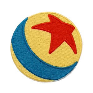 Op de afbeelding: Een cirkelvormige geborduurde patch met een gele achtergrond en een grote, vijfpuntige rode ster in het midden. Een dikke, gebogen blauwe streep loopt langs de linkerkant van de cirkel, wat zorgt voor een opvallend grafisch ontwerpelement.