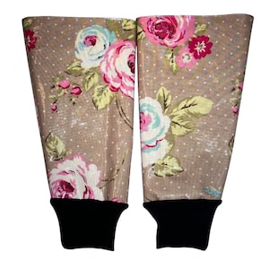 May include: A pair of brown floral leg warmers with black cuffs. The floral pattern features pink, white, and blue roses on a brown background with white polka dots.