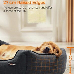 May include: A dog bed with 27 cm raised edges, designed to relieve pressure on the neck. The bed is dark gray with a grid pattern and the brand name "Feandrea". A golden retriever is resting comfortably inside.