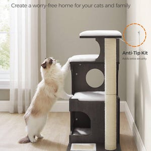 May include: A dark brown multi-level cat tree with a scratching post and cushioned platforms. The text reads "Stable & Safe" and "Anti-Tip Kit". The cat tree has a large base for stability. A cat is shown interacting with the cat tree.