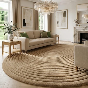 May include: A living room featuring a beige sofa with green throw pillows, a round rug with concentric circles, and a crystal chandelier. The room has neutral tones, with beige curtains and artwork in gold frames. A fireplace and side tables complete the decor.
