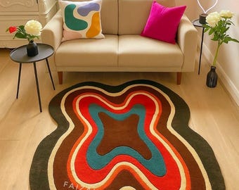 May include: A colorful, abstract area rug with a wavy, layered design. The rug features a dark green border, followed by cream, brown, red, and teal layers. The text "FAIZAHAN MADE RUGS" is visible on the rug.