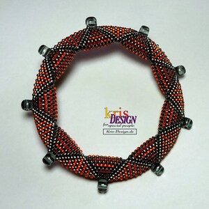 May include: A beaded bracelet with a spiral design in orange and gray. The bracelet is made with small seed beads and has a silver finish.
