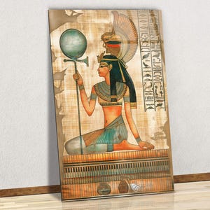 May include: An Egyptian-themed wall art print. The artwork depicts a seated figure in traditional attire, holding a staff with a circular top. The color palette includes earthy tones, blues, and gold accents. Hieroglyphs are visible on the right side of the print.