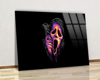 May include: A black framed art print featuring a colorful illustration of the Ghostface mask from the Scream movie franchise. The mask is depicted with vibrant purple, orange, and yellow hues, with dripping paint effects. The artwork is set against a black background.