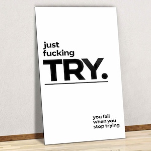 May include: A rectangular white wall art print featuring bold black text that reads just fucking TRY. with a horizontal line underneath the word TRY. Below this, smaller black text reads you fail when you stop trying in a sans-serif font.