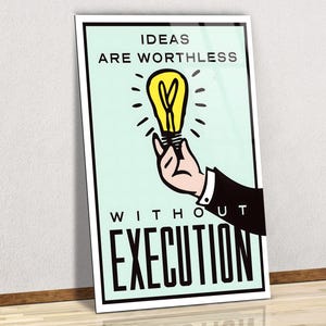 May include: A framed poster with the text "IDEAS ARE WORTHLESS WITHOUT EXECUTION." The poster features a hand holding a yellow lightbulb with radiating lines on a light green background. The hand is wearing a black suit jacket.