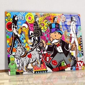 May include: A vibrant pop art canvas print featuring a collage of iconic figures and symbols. The artwork includes images of The Beatles, Monopoly's Mr. Monopoly, and a Lego figure, with text elements like "Always Love" and "Lucky Strike".
