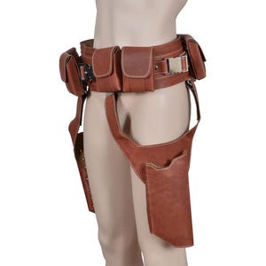 May include: Brown leather utility belt with multiple pouches and a silver buckle. The belt includes a thigh holster and additional pouches for carrying items. The leather has a slightly distressed appearance.