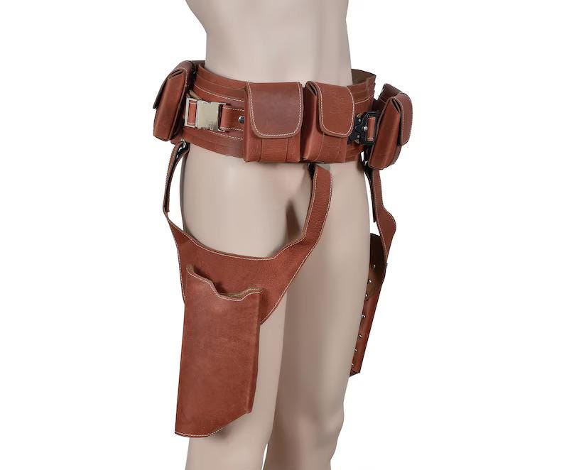 May include: Brown leather utility belt with multiple pouches and a thigh holster. The belt features a metal buckle and is designed to be worn around the waist. The pouches are rectangular and secured with flaps.