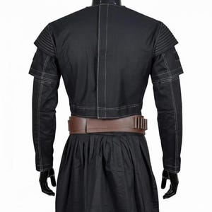 May include: A set of three ceramic mugs with a speckled, matte finish. The mugs are in shades of cream, light grey, and dark grey. Each mug has a simple, minimalist design and a rounded handle. The mugs are stacked on top of each other.