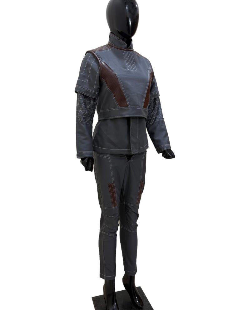 May include: A gray two-piece outfit displayed on a mannequin. The jacket has brown accents on the shoulders and chest, with white stitching. The pants are gray with brown accents and white stitching. The outfit is designed with a futuristic aesthetic.