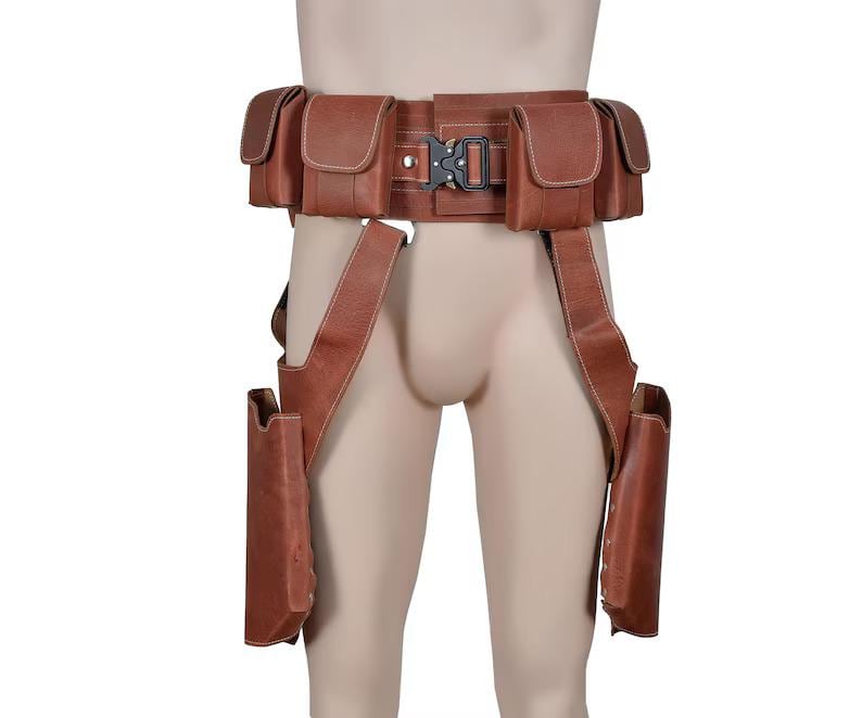 May include: Brown leather utility belt with multiple pouches and a buckle closure. The belt has suspenders that attach to two additional pouches. The belt is designed to be worn around the waist and thighs.