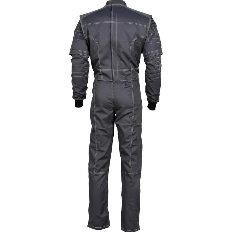 May include: A gray racing suit with white stitching details. The suit features a full-body design with long sleeves, a stand-up collar, and black cuffs. The stitching creates a grid-like pattern on the shoulders and chest, and runs along the arms and legs.