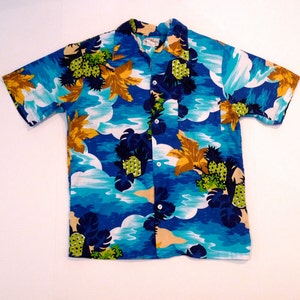 May include: Short-sleeved button-down shirt with a tropical print. The shirt features a vibrant design with blue, turquoise, and white clouds, along with yellow and green foliage and pineapples. The shirt has a classic collar and a single chest pocket.