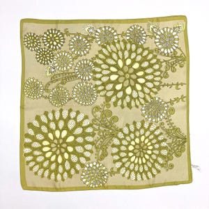 May include: Square scarf with a floral pattern in shades of olive green, cream, and beige. The design features large, stylized flowers and smaller floral accents, with a solid olive green border.