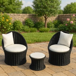 May include: Outdoor wicker furniture set featuring two black armchairs with white cushions and pillows, and a matching side table. The chairs have a rounded back design, perfect for a patio or garden setting.