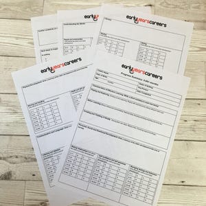 May include: A stack of white paper sheets with the "early years careers" logo in red and black. The sheets contain tables and text related to child development and progress summaries. The papers are arranged on a light wood-grain surface.