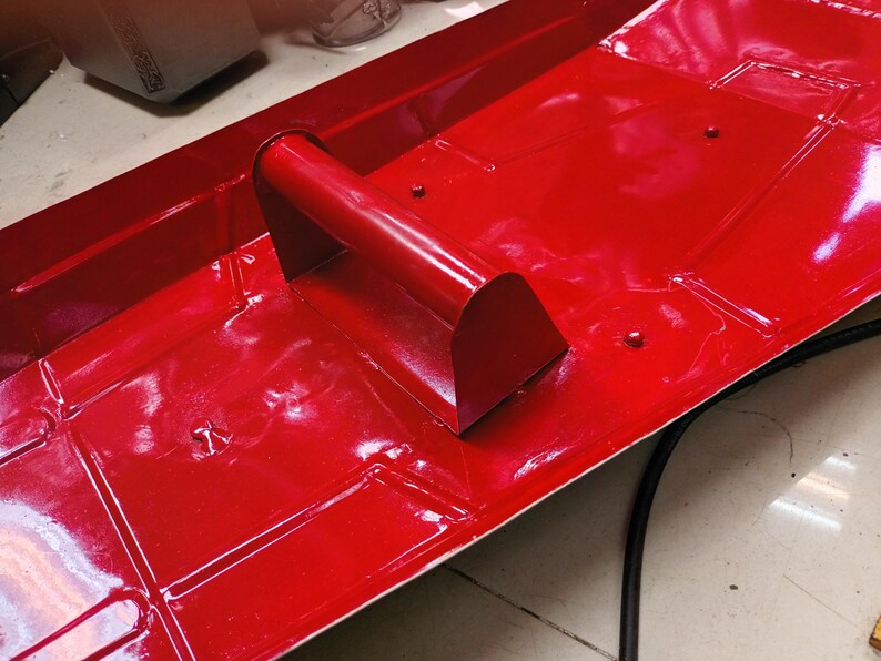 K&ouml;nnte beinhalten: Eine leuchtend rote Metallschale mit einem gebogenen Griff. Die Schale hat eine rechteckige Form mit quadratischen Vertiefungen. Der Griff ist ein abgerundetes Rechteck. Die Oberfl&auml;che ist gl&auml;nzend.