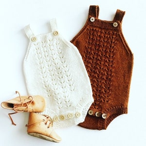May include: Two knitted baby onesies, one white and one brown, with button closures. The onesies have a delicate, lacy pattern.