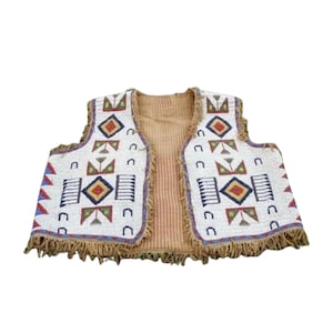 May include: A white beaded vest with geometric patterns in red, blue, yellow, and green. The vest has a tan interior and a fringed hem. The design includes diamond and rectangular shapes.
